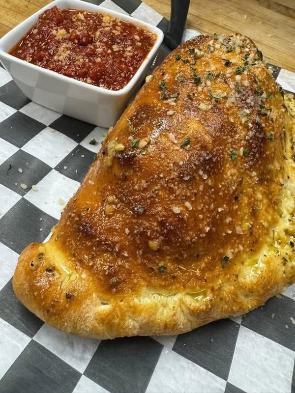 Baked pub food with marinara on checkered paper