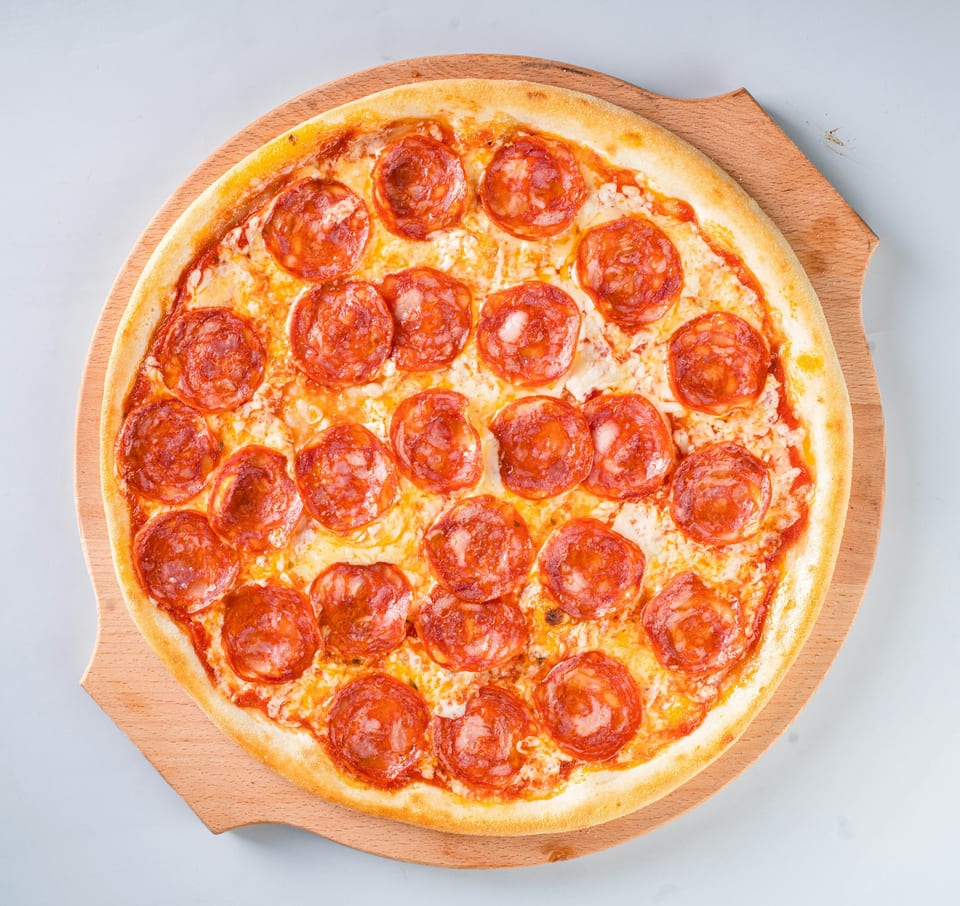Pepperoni pizza on a wooden board